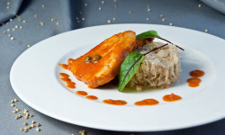 biały talerz na talerzy kiszona kapusta obok kawałek mięsa oblany pomidorowym sosem 