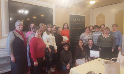 Grupa 15 kobiet stoi  pozując do zdjęcia. 