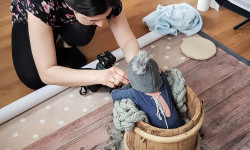 Zdjęcie ukazuje fotografa w czasie pracy z dzieckiem