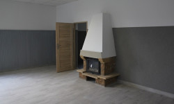 Zdjęcie przedstawia wnętrze budynku z kominkiem