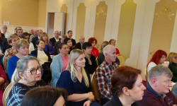 Konferencja LGD. Hrubieszów. Kobiety i mężczyźni siedzą  na krzesłach d dużej sali.