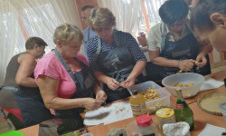 w sali grupa kobiet przy stole na którym są produkty spożywcze